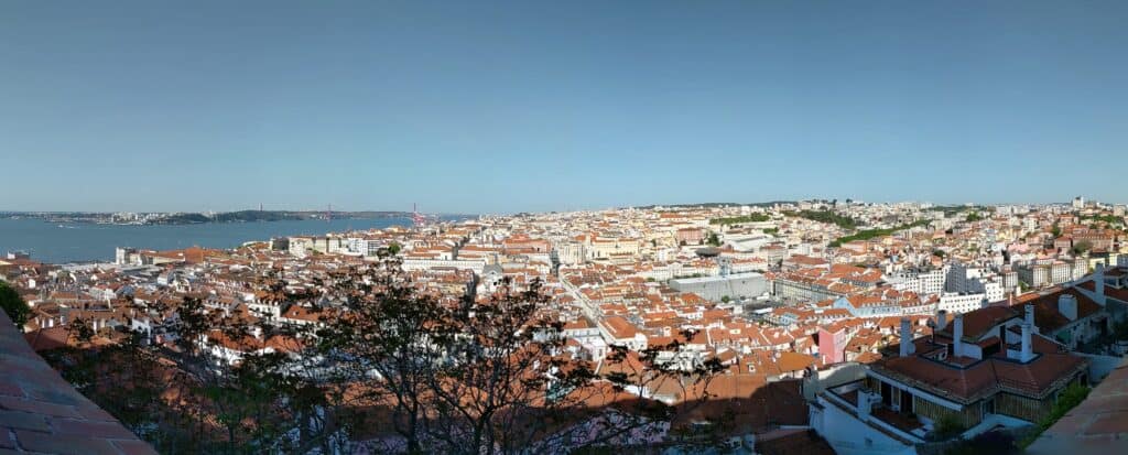 View of the city from the Castelo Sao Jorge. Clay red rooftops and white buildings.