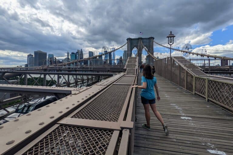Brooklyn Bridge with Manhattan and dark clouds in the background.