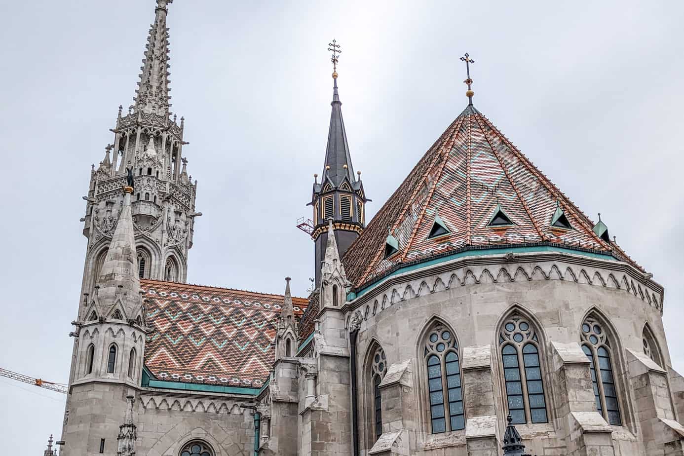 The tiled rooftop of Matthias Church with geometric shapes in red, white, and teal tiles.