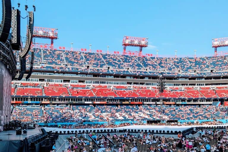 A stadium mostly full of people with a blue sky.