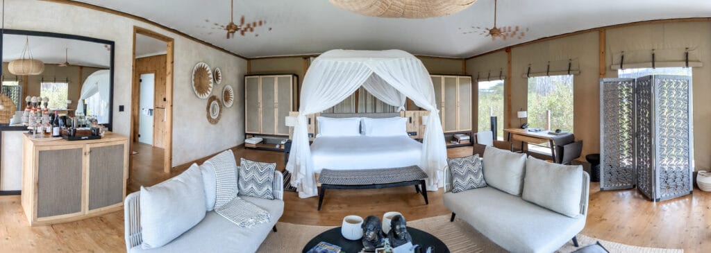 Interior of room at JW Marriott Masai Mara lodge - canopied bed and lounge area
