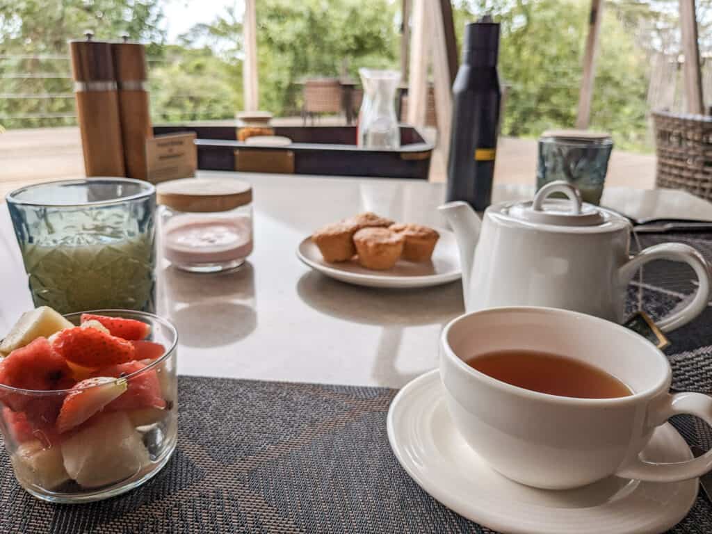 breakfast table at JW Marriott Masai Mara- tea, fruit , and gluten-free muffins