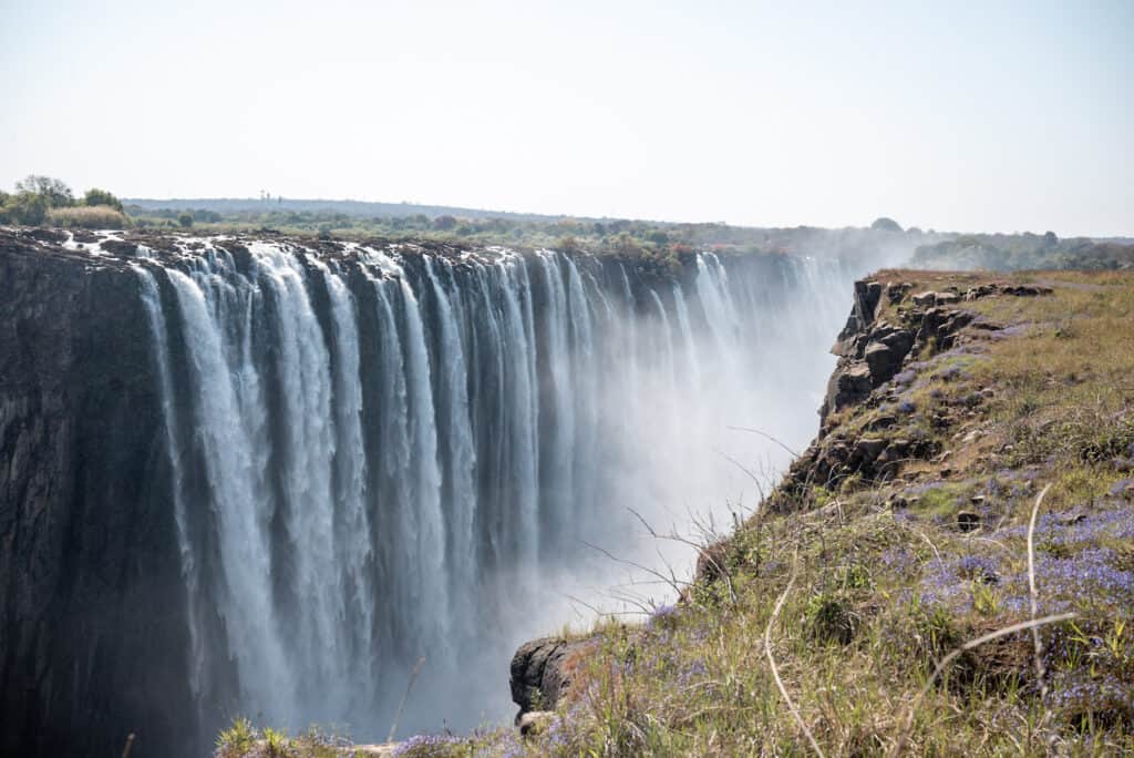 Several thin tall waterfalls cascade over the side of Victoria Falls